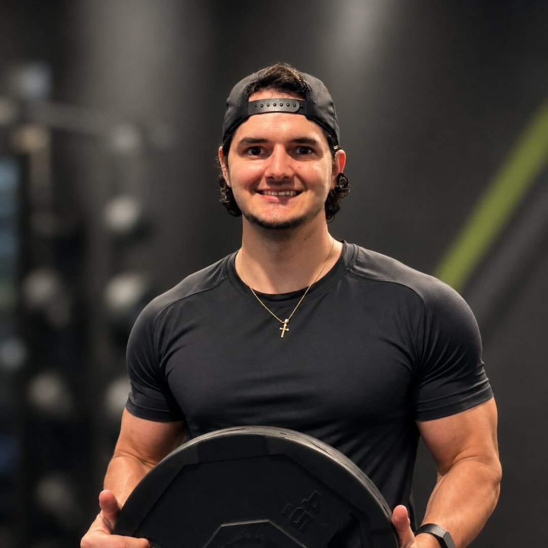 Lucas Lacerda holding a weight plate in the gym